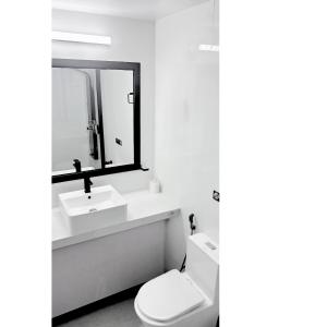 a bathroom with a toilet and a sink and a mirror at Alyraa sunset in Mathiveri