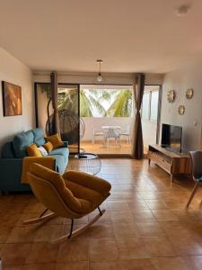 een woonkamer met een blauwe bank en een stoel bij Ti Paradis Doré in Schœlcher