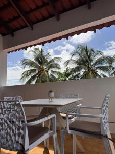 een eetkamer met een tafel en stoelen en palmbomen bij Ti Paradis Doré in Schœlcher +13 foto's