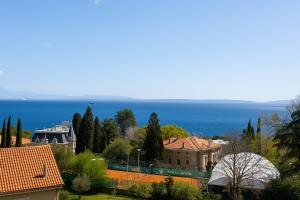 einen Blick auf ein Haus mit dem Meer im Hintergrund in der Unterkunft Blue Horizon Studio Opatija in Opatija + 5 Fotos