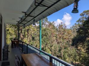 a balcony with a table and a view of trees at Ella South Star in Ella