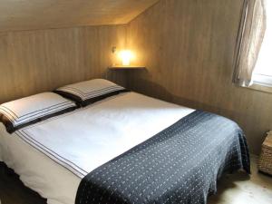 Una cama en una habitación pequeña con una lámpara. en De Berghut, en Stadl an der Mur