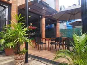 un ristorante con tavolo, sedie e ombrellone di Smart Malls Flats a Belém