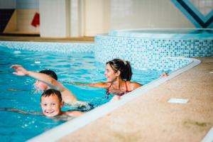 Thurston Essential Clover Caravan 3 في دنبار: مجموعة من الأشخاص في حمام السباحة