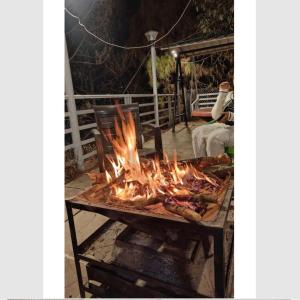 ein großer Grill mit Flammen auf einer Terrasse in der Unterkunft Rudrashray Paradise Mussorie in Masuri