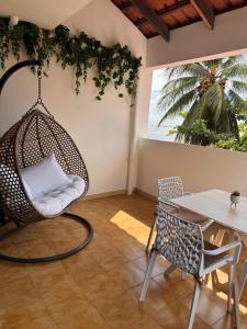 een kamer met een hangstoel en een tafel bij Ti Paradis Doré in Schœlcher