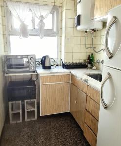 a small kitchen with a sink and a microwave at Del Paseo al Mar in Mar del Plata