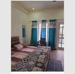 Schlafzimmer mit einem großen Bett und blauen Vorhängen in der Unterkunft Rudrashray Paradise Mussorie in Masuri + 7 Fotos