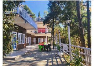 eine Veranda eines Hauses mit einem Tisch und Stühlen in der Unterkunft Rudrashray Paradise Mussorie in Masuri