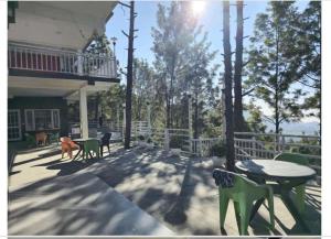 eine Terrasse mit einem Tisch und Stühlen sowie einem Balkon in der Unterkunft Rudrashray Paradise Mussorie in Masuri