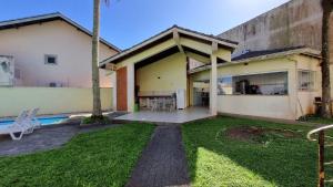 ein Haus mit einem Garten mit einem Swimmingpool in der Unterkunft Casa da praia pousada in Peruíbe