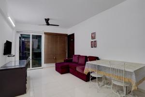 una sala de estar con un sofá y una mesa en Collection O Magarpatta City Formerly Ekab Hospitality, en Mundhwa