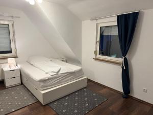 een kleine slaapkamer met een bed en een raam bij Westerwald Apartments - Das große Ferienhaus, zentral und ruhig, einfach gut! in Heiligenroth