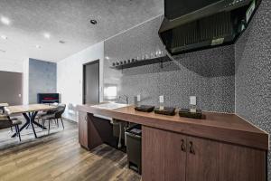 a kitchen with a counter and a table and chairs at Prostimo in Bibai