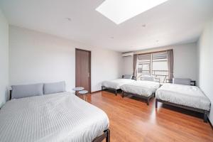 a room with three beds and a window at Prostimo in Bibai +86 photos
