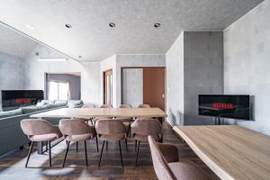 a dining room with a table and chairs and a couch at Prostimo in Bibai