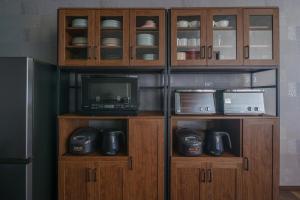 a kitchen with wooden cabinets with a tv and a microwave at Prostimo in Bibai