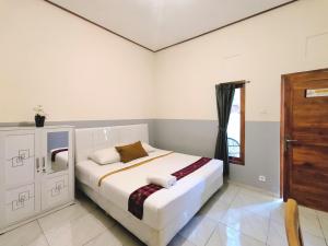 a bedroom with a bed and a window in it at Guest House 88 Pandawa in Nusa Dua