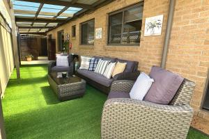 a patio with two couches and a table on the grass at LUXURY 3-Bed Home Perfect for Families & Groups in Sebastopol