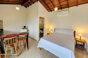 um quarto com uma cama e uma mesa com cadeiras em Chalés Vale dos Pássaros Refúgio nas montanhas em Paraty