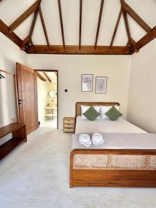 een slaapkamer met een bed met twee handdoeken erop bij Uma Resort Togean in Katupa