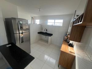 a kitchen with a stainless steel refrigerator and a sink at Praia de Guaibim in Valença
