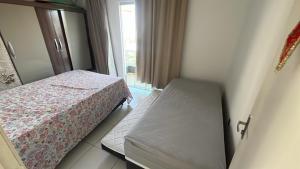 a bedroom with two beds and a window at Praia de Guaibim in Valença