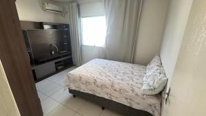 a bedroom with a bed and a flat screen tv at Praia de Guaibim in Valença