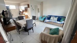 a living room with a couch and a table and chairs at Praia de Guaibim in Valença