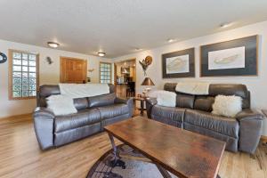 a living room with two leather couches and a coffee table at Otter Run in Bend