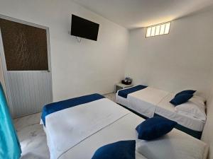 ein Zimmer mit zwei Betten und einem Flachbildfernseher in der Unterkunft Proyecto tour yuma tatacoa in Villavieja