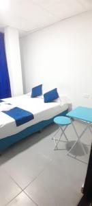 ein Bett mit zwei Kissen und einem Tisch in einem Zimmer in der Unterkunft Proyecto tour yuma tatacoa in Villavieja