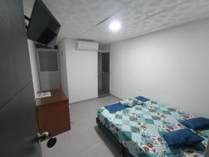 ein Schlafzimmer mit einem Bett und einem Fernseher darin in der Unterkunft Proyecto tour yuma tatacoa in Villavieja