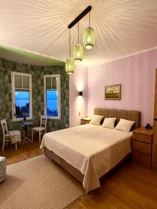 ein Schlafzimmer mit einem großen Bett und zwei Fenstern in der Unterkunft Blue Horizon Studio Opatija in Opatija