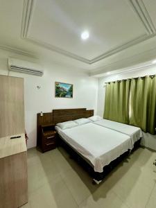 a bedroom with a large bed with a green curtain at Hotel Luci in Terra Santa