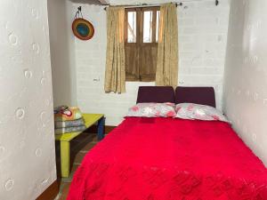 a bedroom with a red bed with a window at Serene Soul Arroyave in Medellín