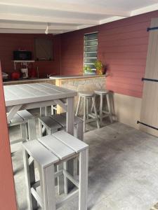 eine Küche mit Tischen und Stühlen in einem Zimmer in der Unterkunft Le Tomaflo in Le Marin