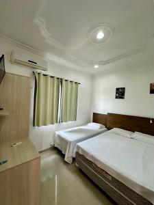 a bedroom with two beds and a window at Hotel Luci in Terra Santa +7 photos