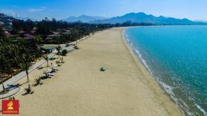 une vue aérienne d'une plage avec des palmiers et l'océan dans l'établissement Salt & Wind Living - Phan Rang Beachfront, à Bắc Sớn