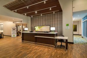 a lobby with a waiting area with a counter and a bench at Holiday Inn Joplin by IHG in Joplin +55 photos
