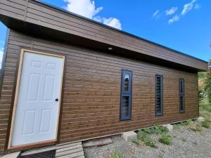 a wooden building with a white door on it at Tiny 2 in Los Ángeles
