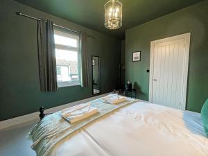 ein Schlafzimmer mit einem Bett, auf dem zwei Handtücher liegen in der Unterkunft Botany Bay House in Whitby + 14 Fotos