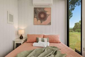 een slaapkamer met een groot bed en een raam bij Olive Sanctuary by Tiny Away in Taggerty