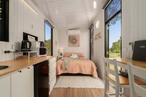 een kleine slaapkamer met een bed in een tiny house bij Olive Sanctuary by Tiny Away in Taggerty