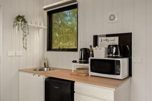 een keuken met een aanrecht met een magnetron en een wastafel bij Olive Sanctuary by Tiny Away in Taggerty