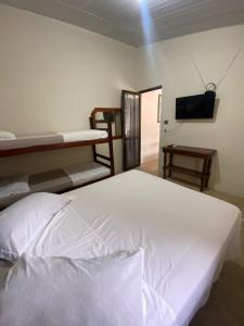 a bedroom with two bunk beds and a flat screen tv at Pousada da Marli in Torres