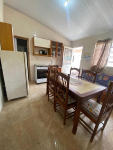 a kitchen with a table and chairs and a refrigerator at Pousada da Marli in Torres