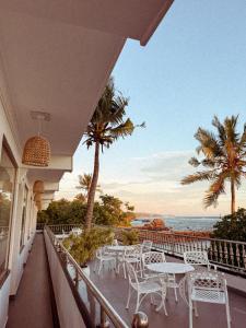 a balcony with tables and chairs and a view of the ocean at Beach House Goviyapana in Ahangama
