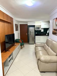 un salon avec un canapé et une cuisine dans l'établissement Praia vila velha, à Vila Velha