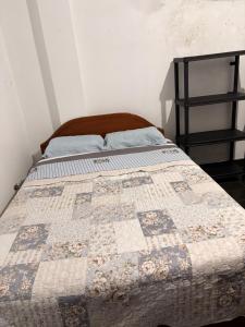 ein Bett mit einer Decke in einem Schlafzimmer in der Unterkunft Kelly Mercedes in Chachapoyas